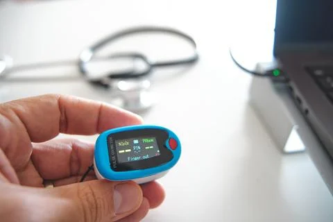 Hand holding pulse oximeter for remote health monitoring Stock Photos