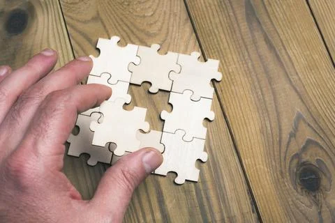 A hand is holding a puzzle piece that is missing Foto stock