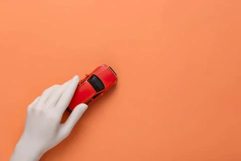 Hand holding a red computer mouse on orange background Stock Photos
