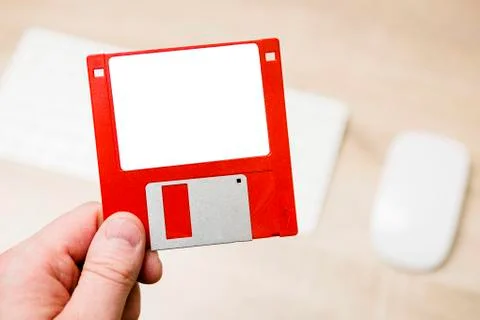 Hand holding a red floppy disk. Stock Photos