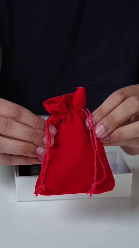Hand Holding Red Pouch Over Oud Chips Stock-Footage 336604521