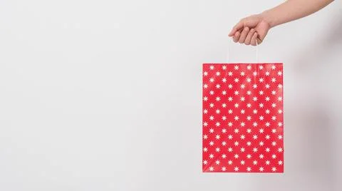 Hand holding red star pattern shopping bag on white background.copy space. Stock Photos