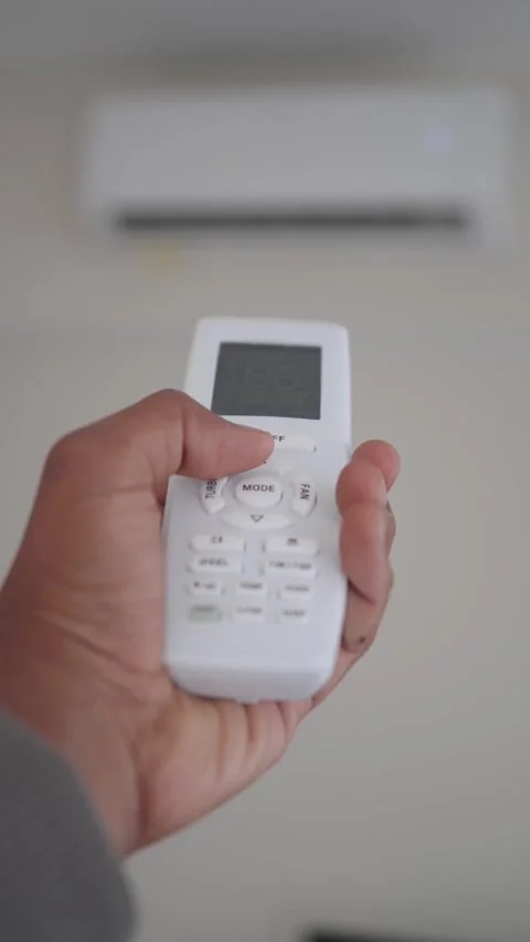Hand holding a remote control for an air conditioning unit at home Stock-Footage 346268053
