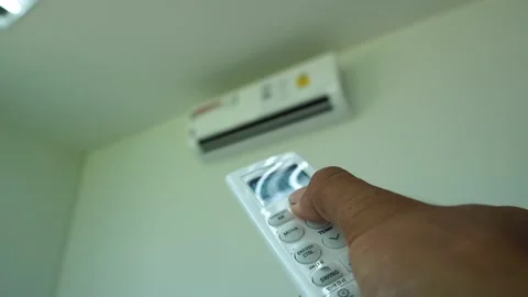 Hand holding a remote control and adjust the temperature of air conditioner Stock Footage 158887151
