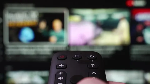 Hand Holding a Remote Control Browses Various Streaming Services Stock Footage 340780171