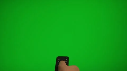 Hand holding remote control pointing at green screen TV mockup. Stock Footage 340556492