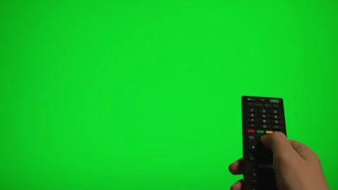 Hand holding remote control pointing at green screen TV mockup. Stock Footage 340556532