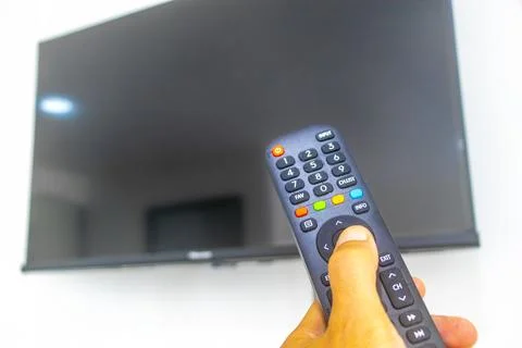 Hand Holding Remote Control Turning On Television In Thai Hotel Room Thailand Stock-Fotos