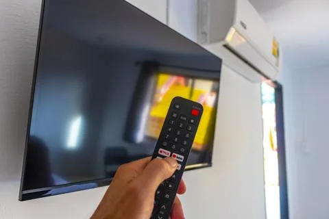 Hand Holding Remote Control Turning On Television In Thai Hotel Room Thailand Stock Photos