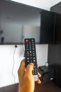 Hand Holding Remote Control Turning On Television In Thai Hotel Room Thailand Stock-Fotos