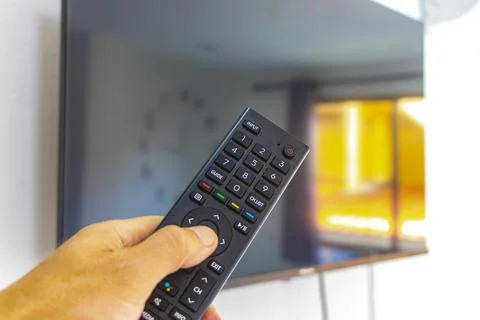 Hand Holding Remote Control Turning On Television In Thai Hotel Room Thailand Stock-Fotos