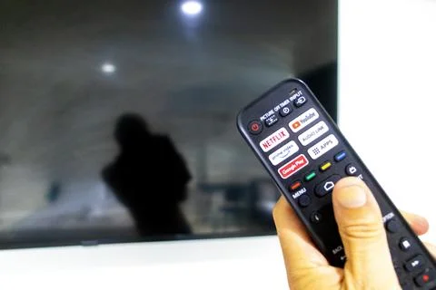 Hand Holding Remote Control Turning On Television In Thai Hotel Room Thailand Stock-Fotos