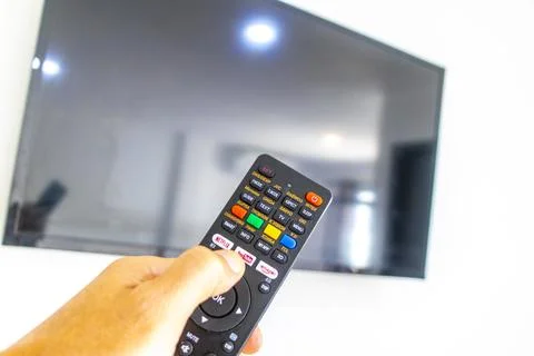 Hand Holding Remote Control Turning On Television In Thai Hotel Room Thailand Stock-Fotos