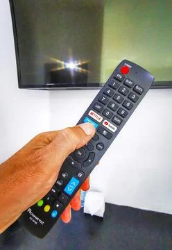 Hand Holding Remote Control Turning On Television In Thai Hotel Room Thailand Stock-Fotos