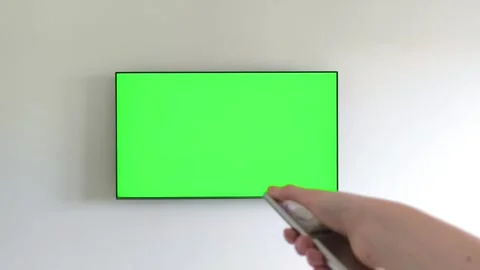 Hand holding a remote control turns off a television with a green chroma ke.. Stock Footage 337172223
