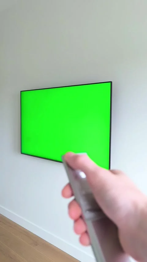 Hand holding a remote control turns off a television viewed from an angle a.. Stock Footage 337172309