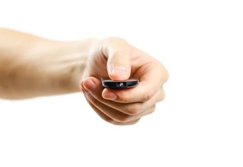 The hand holding the remote. The remote aimed at the camera. Isolated on whit Stock-Fotos
