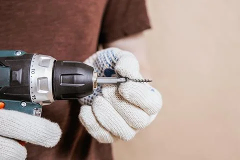 Hand Holding Screw and Drill With Work Gloves Stock Photos