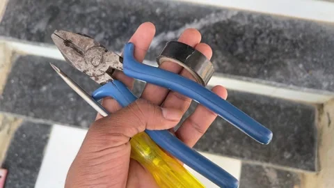Hand Holding Screwdriver, Tape, and Pliers – Essential Home Repair Tools Видео 318840331