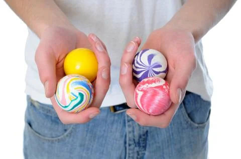 Hand holding a set of four round bouncy rubber balls with colorful designs on Stock Photos