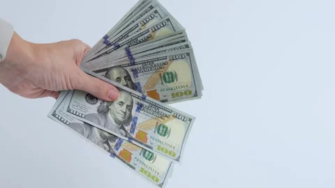A hand holding several hundred dollar bills. The bills are neatly arranged, Stock Footage 311136086