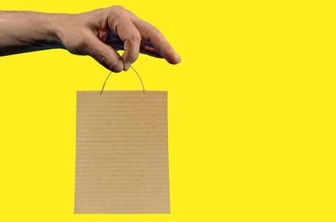 Hand Holding Shopping Bag on Blue Background Advertising Mockup and Retail .. Foto stock