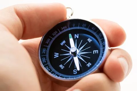 Hand holding silver black compass Foto stock