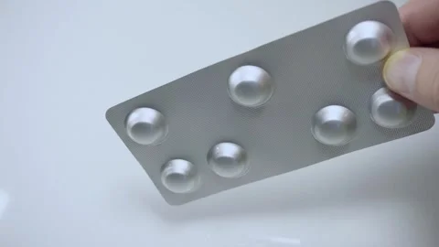 Hand holding silver blister pack with pills close up on white background 스톡 동영상 342838852