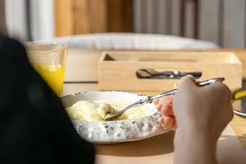 A hand holding a silver fork eating creamy mashed potatoes with melted chee.. Stock Photos