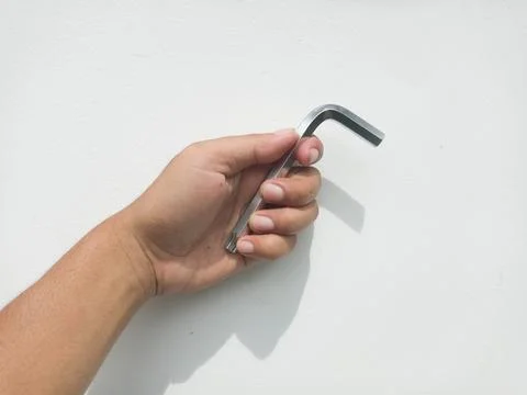 Hand holding silver hex key tool Stock Photos