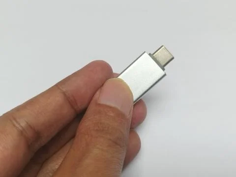 Hand holding silver metallic micro USB Type C OTG adapter Stock-Fotos