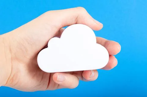 Hand holding a simple white cloud symbol, cloud computing technology metaphor Stock Photos