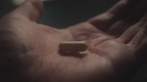 Hand Holding Single Capsule in Dim Light Stock Footage 278513633