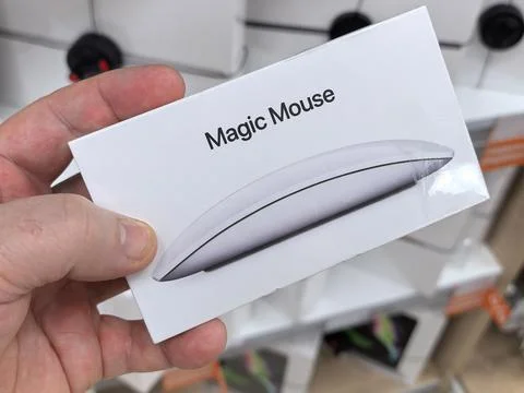 Hand holding a sleek wireless computer mouse in a store display Stock Photos
