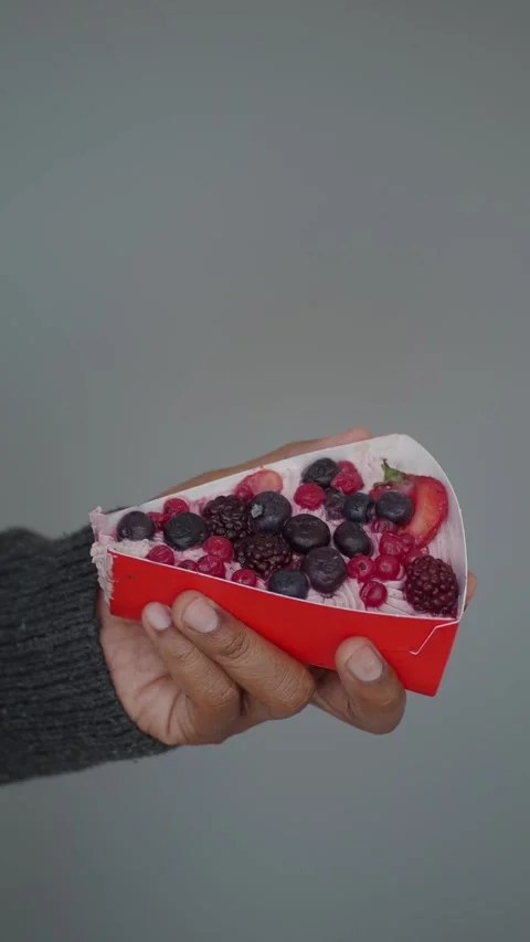 Hand holding a slice of berry cake on gray background Stock Footage 336227096