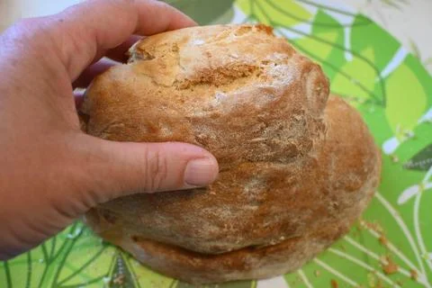 Hand holding slice of bread on plate Stock Photos