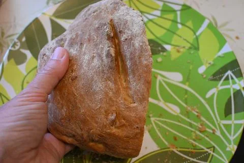 Hand holding slice of bread on plate Stock Photos
