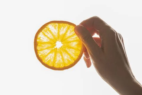 Hand holding a slice of orange Stock Photos