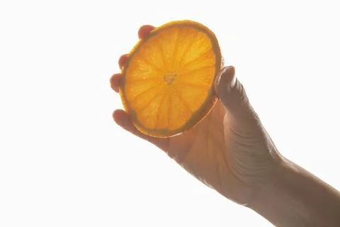 Hand holding a slice of orange Stock Photos