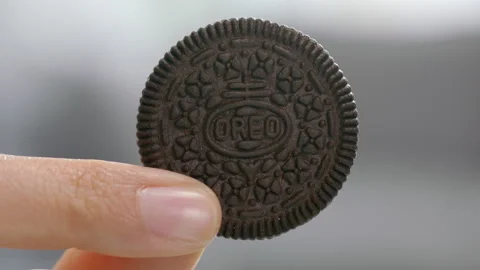 Hand holding a slice of Oreo cookie Stock Footage 240972927