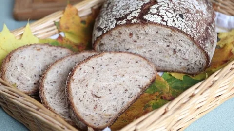 Hand Holding Slices of Multigrain Bread in Basket with Autumn Leaves Stock Footage 298167798