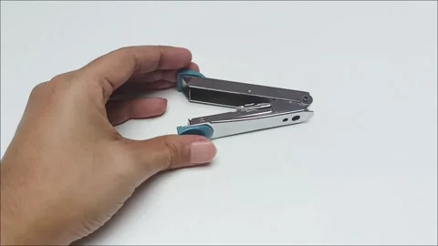 Hand holding a small blue metallic office stapler Stock Footage 338140429