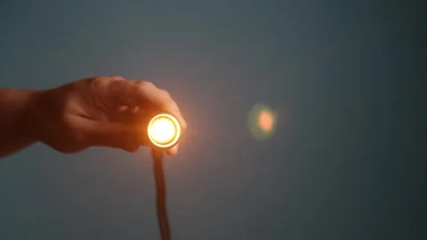 Hand holding a small bright flashlight illuminating the darkness Stock Footage 340266743