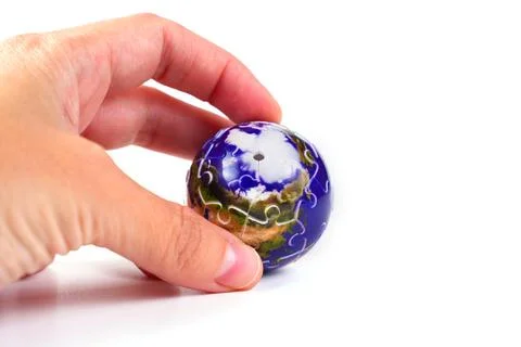 Hand Holding Small Earth Globe Puzzle on White Background Stock Photos