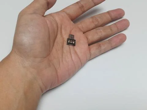 Hand holding small micro USB adapter connector on palm 스톡 사진