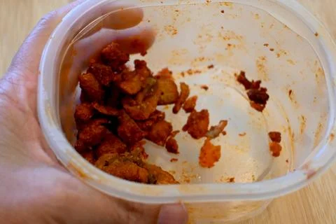 Hand holding small portion of pork cracklings cost of living crisis Fotos Stock