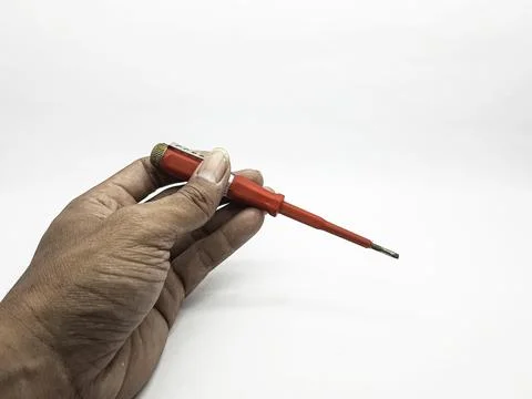 Hand holding a small red electrical testing screwdriver tool Stock Photos