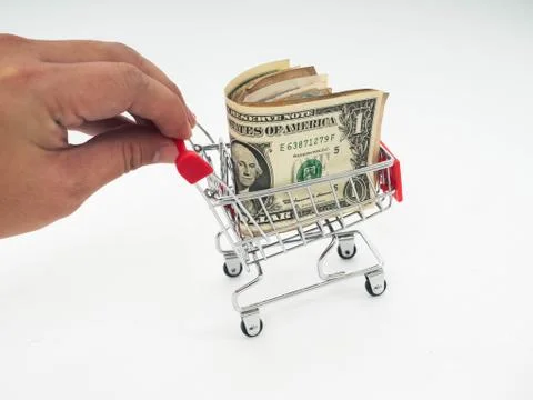 Hand holding small shopping cart with dollar (USD) bills. shopping online or Foto stock
