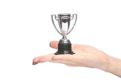 Hand holding small silver trophy cup on white background Stock Photos