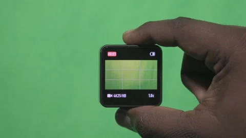 Hand Holding a Small Square Device Against a Green Screen. Stock Footage 342243710